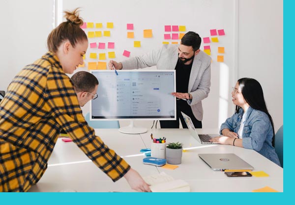 A group of people workshopping with postits and computers