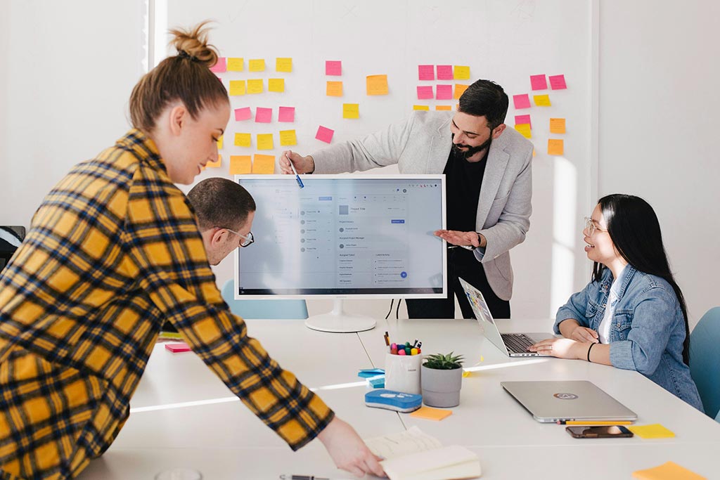 A group of coworkers running a workshop with postits around the room