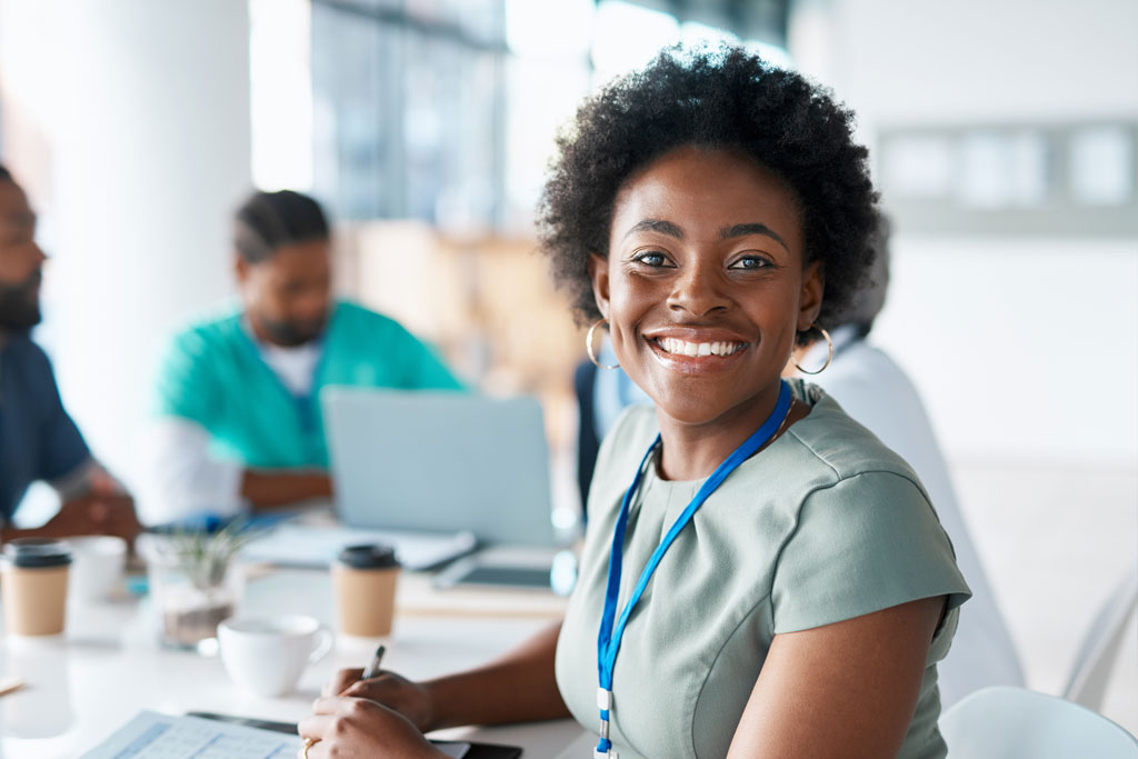 A medical admin turning from a table of papers and smiling