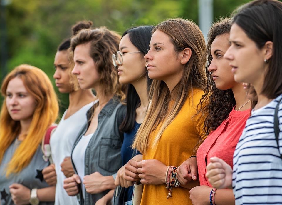 A line of women defiantly standing arm in arm