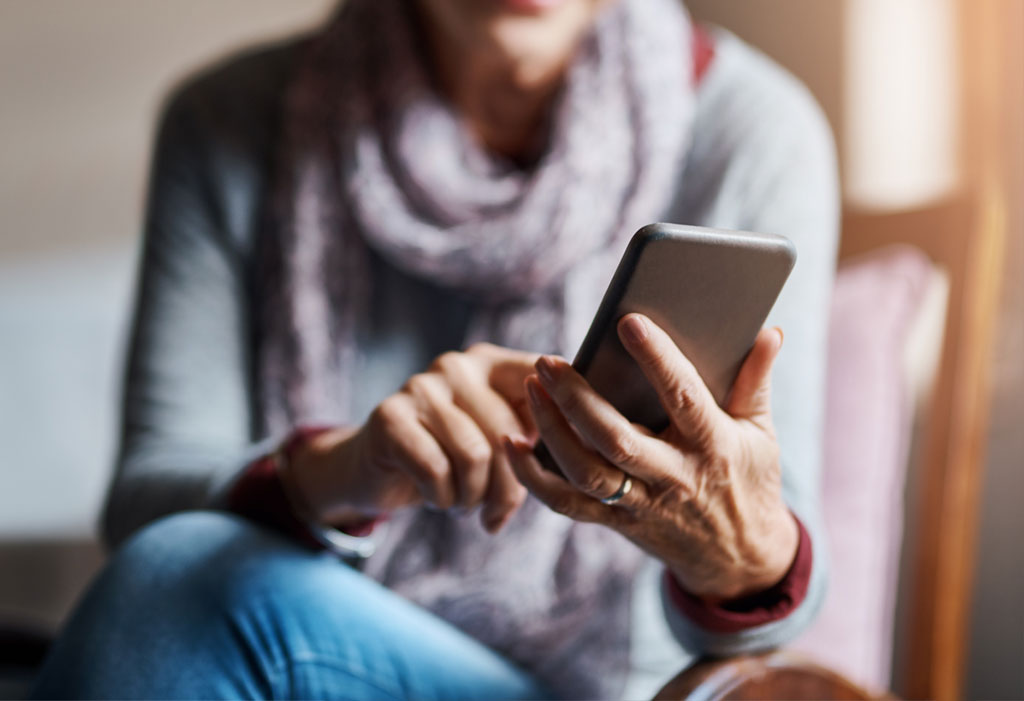 A woman smiling while reading on her phone