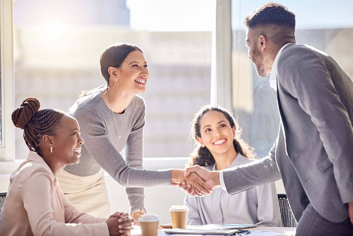 A man and woman shaking hands at the top of a meeting